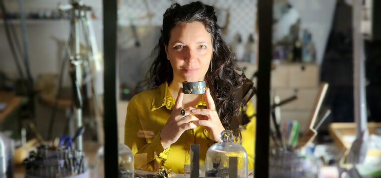 Portrait de Aurore Klein à son atelier, tenant une manchette représentant une Danse de raies manta