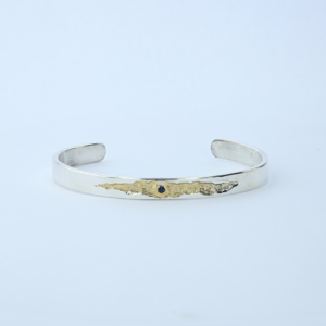 Bracelet jonc en argent massif, fêlure dorée sertie d'un saphir. Pièce unique inspirée de la lumière qui passe par la fêlure. Fait main en Ardèche.